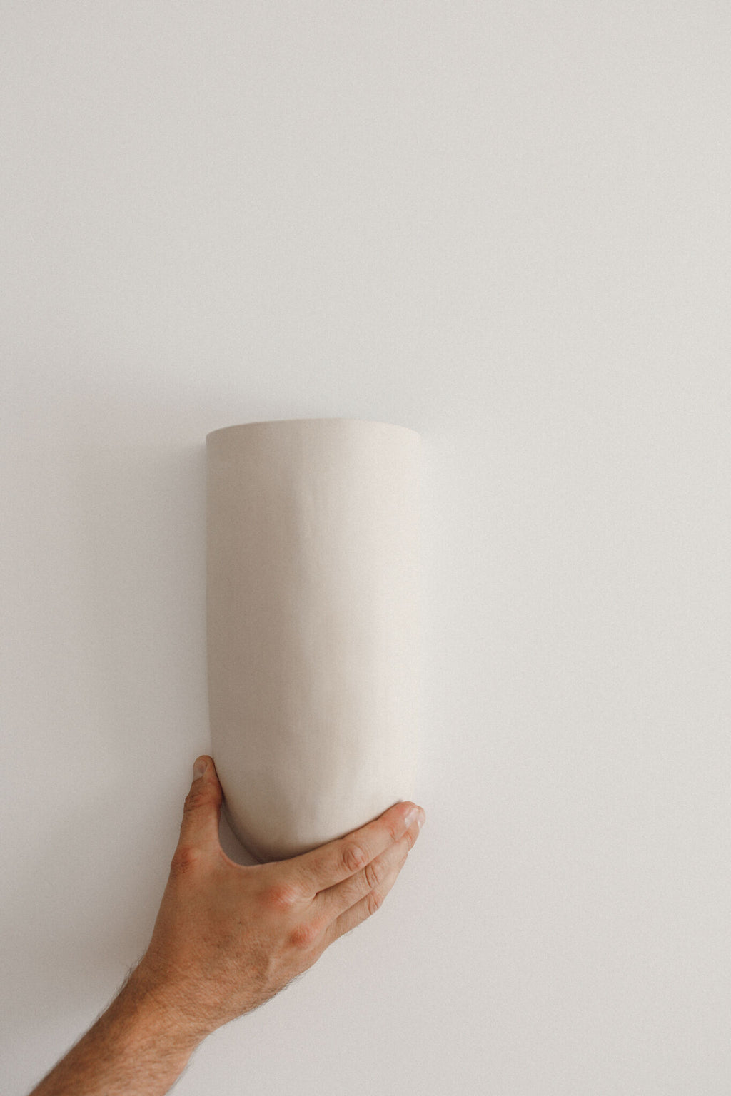 Applique murale blanche en céramique, forme cylindrique, vue depuis le bas.