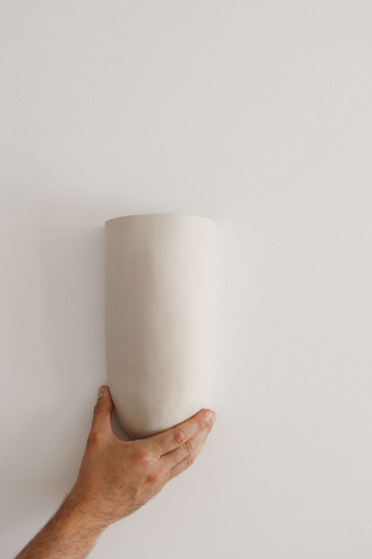 Applique murale blanche en céramique, forme cylindrique, vue depuis le bas.
