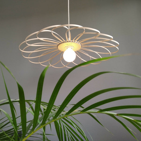 Suspension fleur 55 cm en métal beige, anneau ajouré et ampoule blanche allumée.