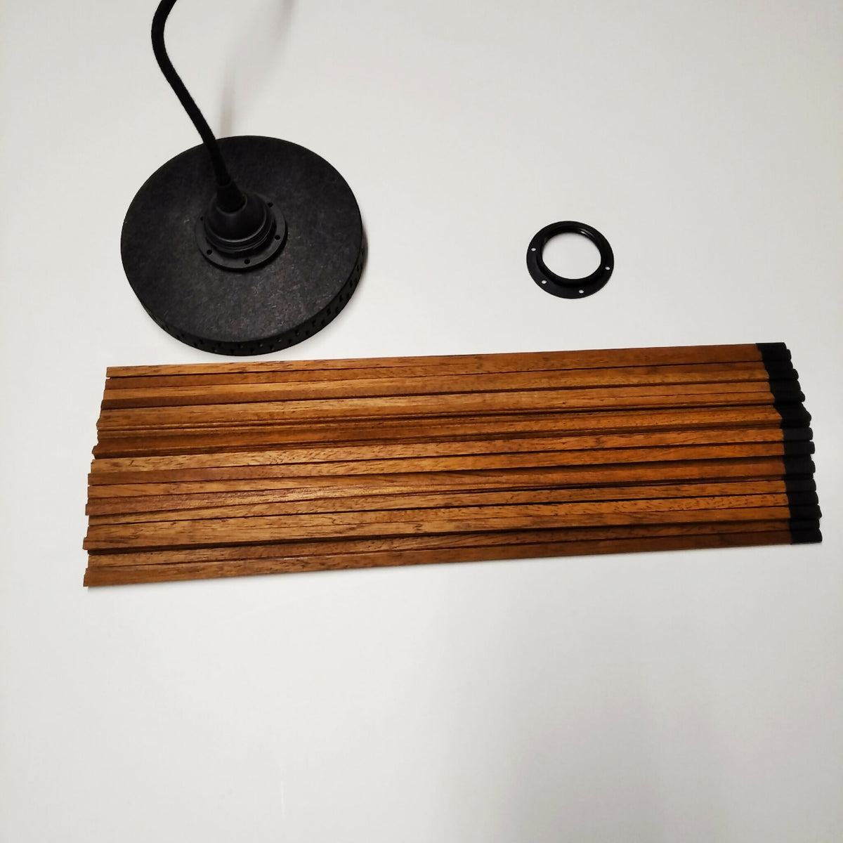 Suspension : rosace noire, câble et barres en bois lamellé pour fixation