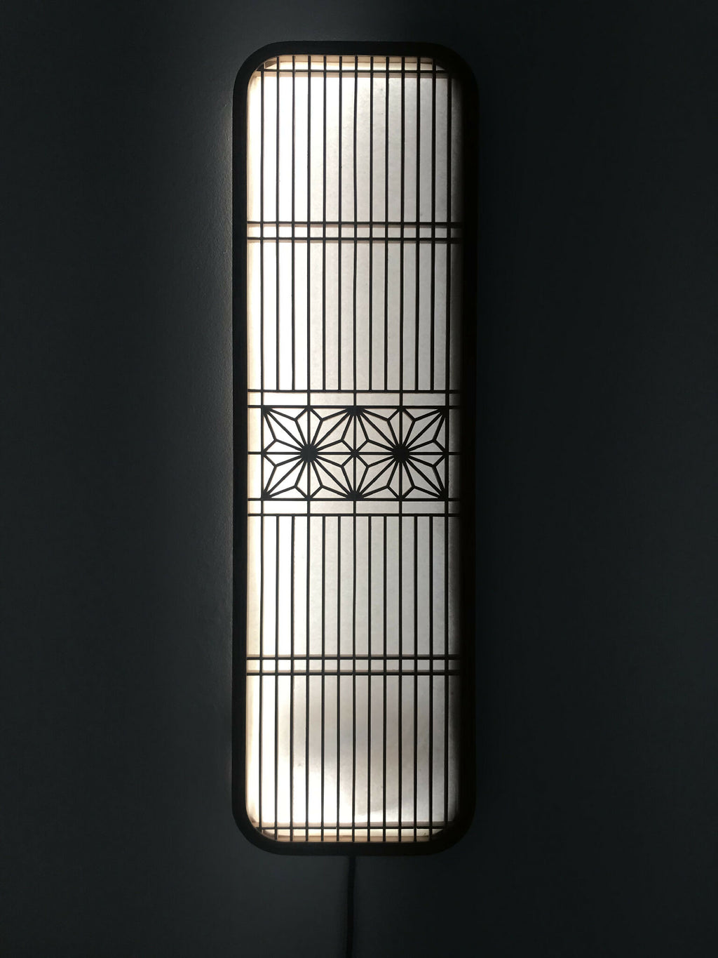 Décoration murale lumineuse Hotaru, cadre rectangulaire bombé, grille et motifs géométriques.