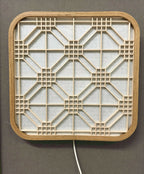 Décoration murale lumineuse Hotaru, structure en bois et grille géométrique interne.