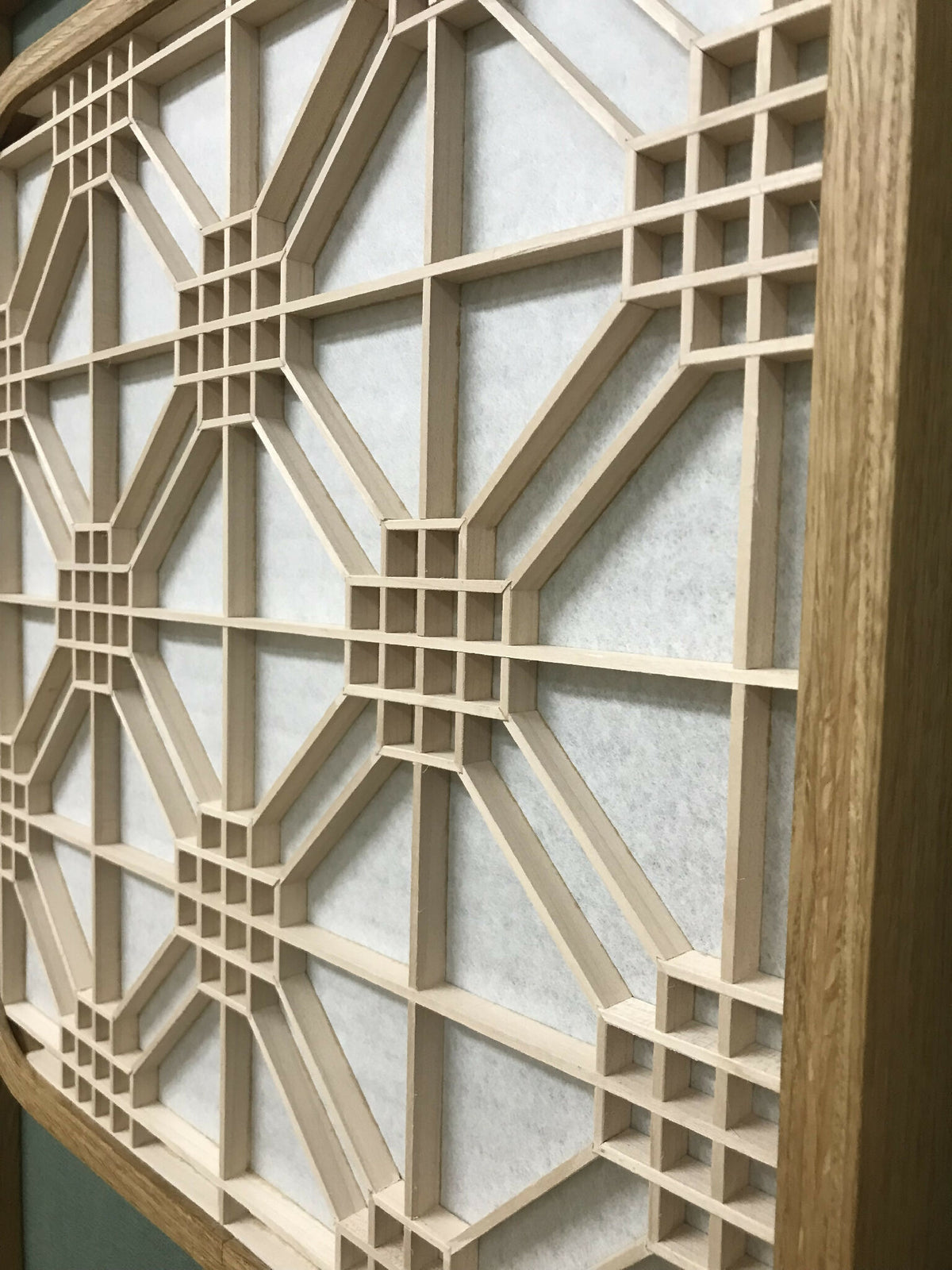 Décoration murale lumineuse Hotaru, détail de la grille géométrique et du cadre en bois.