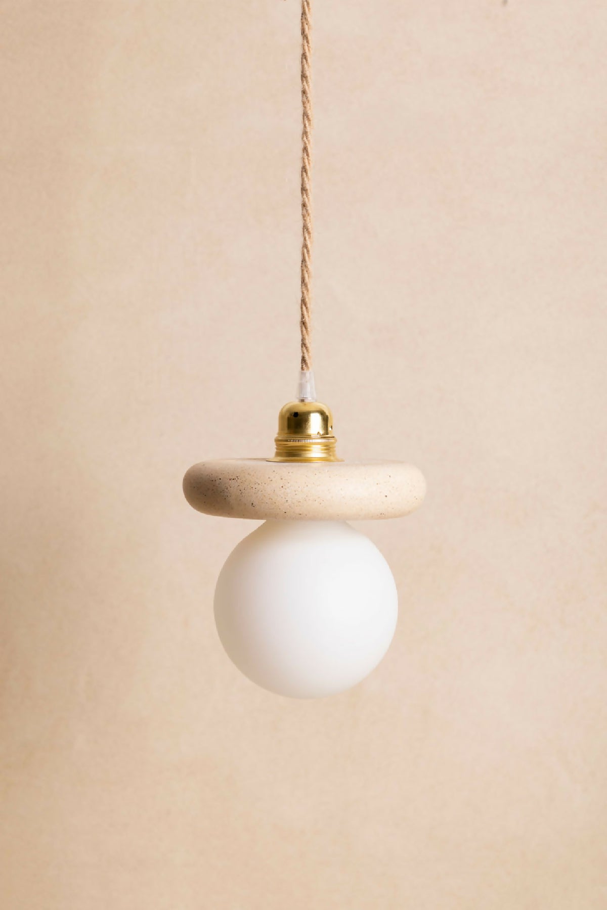 Suspension NORA : ampoule ronde blanche opaline avec capuchon doré et câble torsadé