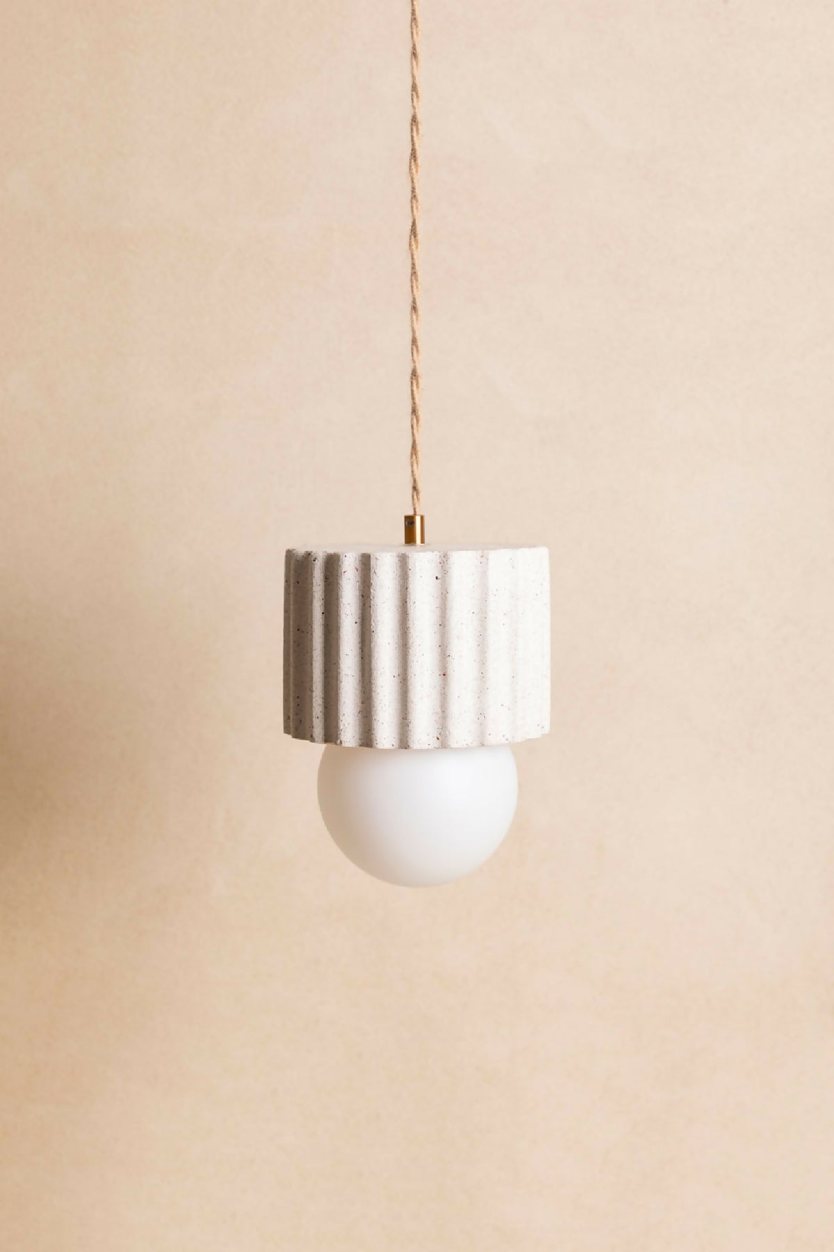 Suspension ILONA à abat-jour cylindrique blanc texturé et ampoule ronde blanche.