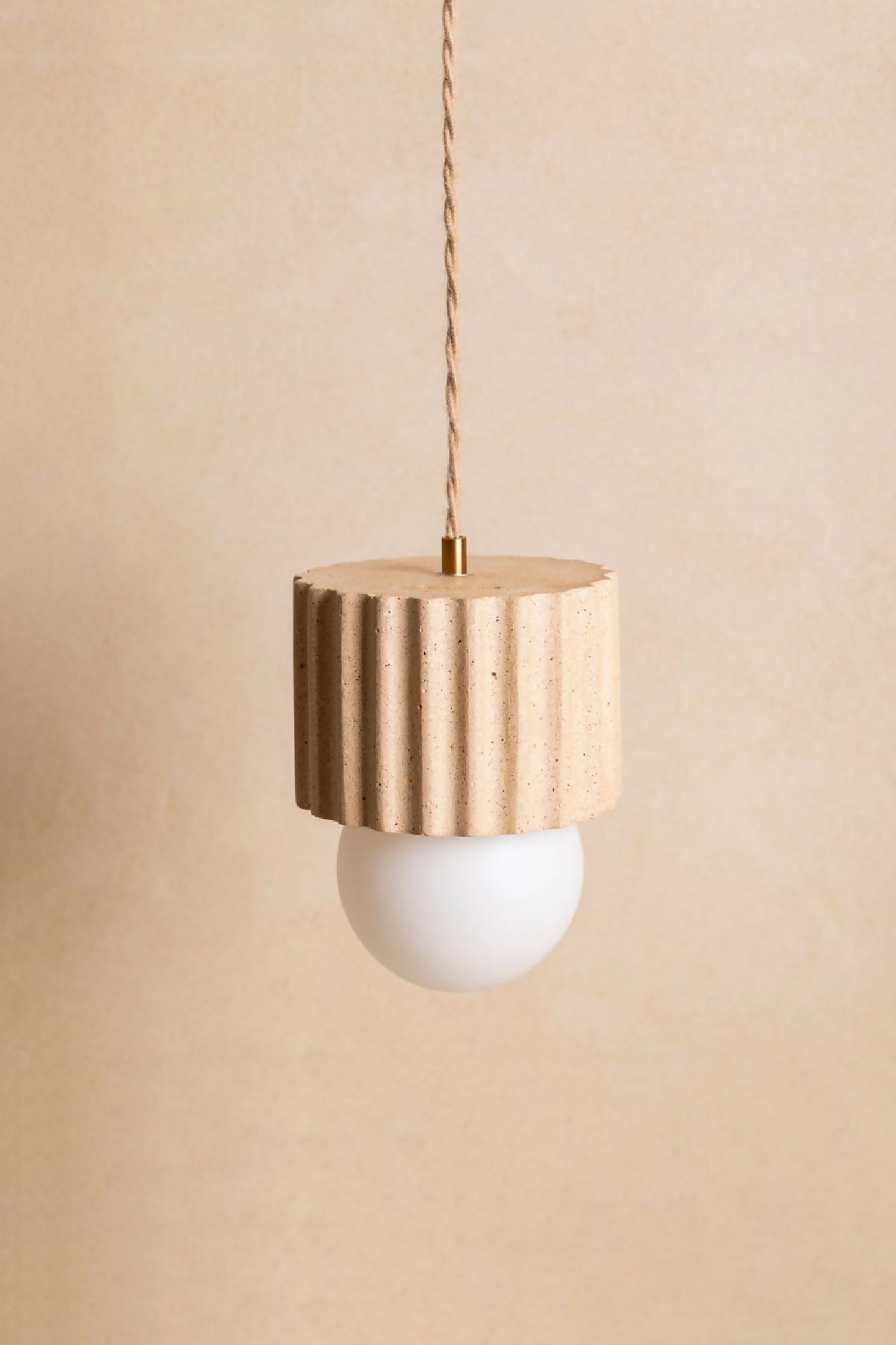 Suspension ILONA à abat-jour cylindrique doré-beige texturé, avec ampoule ronde blanche.