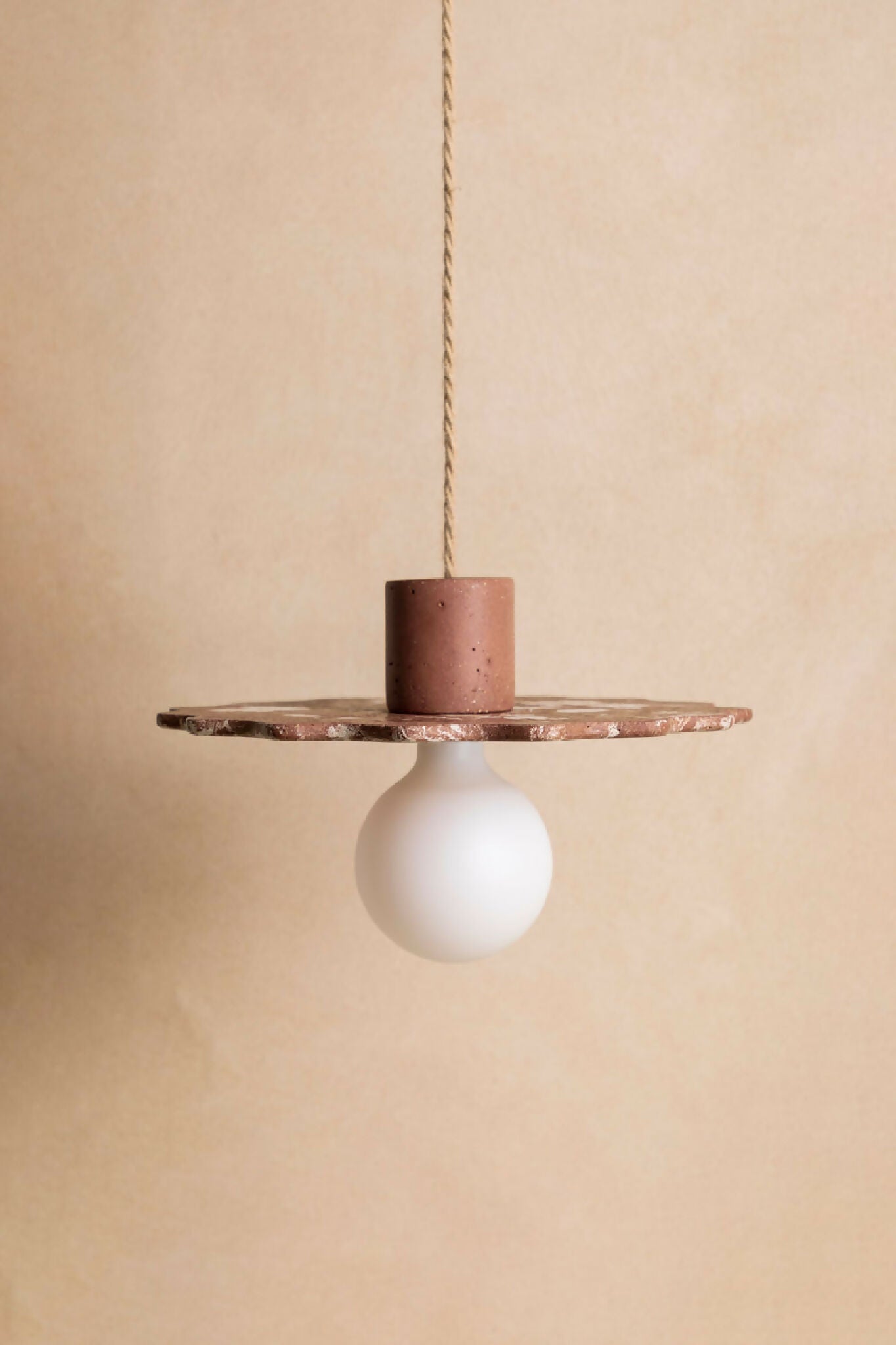 Suspension au diffuseur sphérique blanc, plateau irrégulier en métal finition brun foncé.