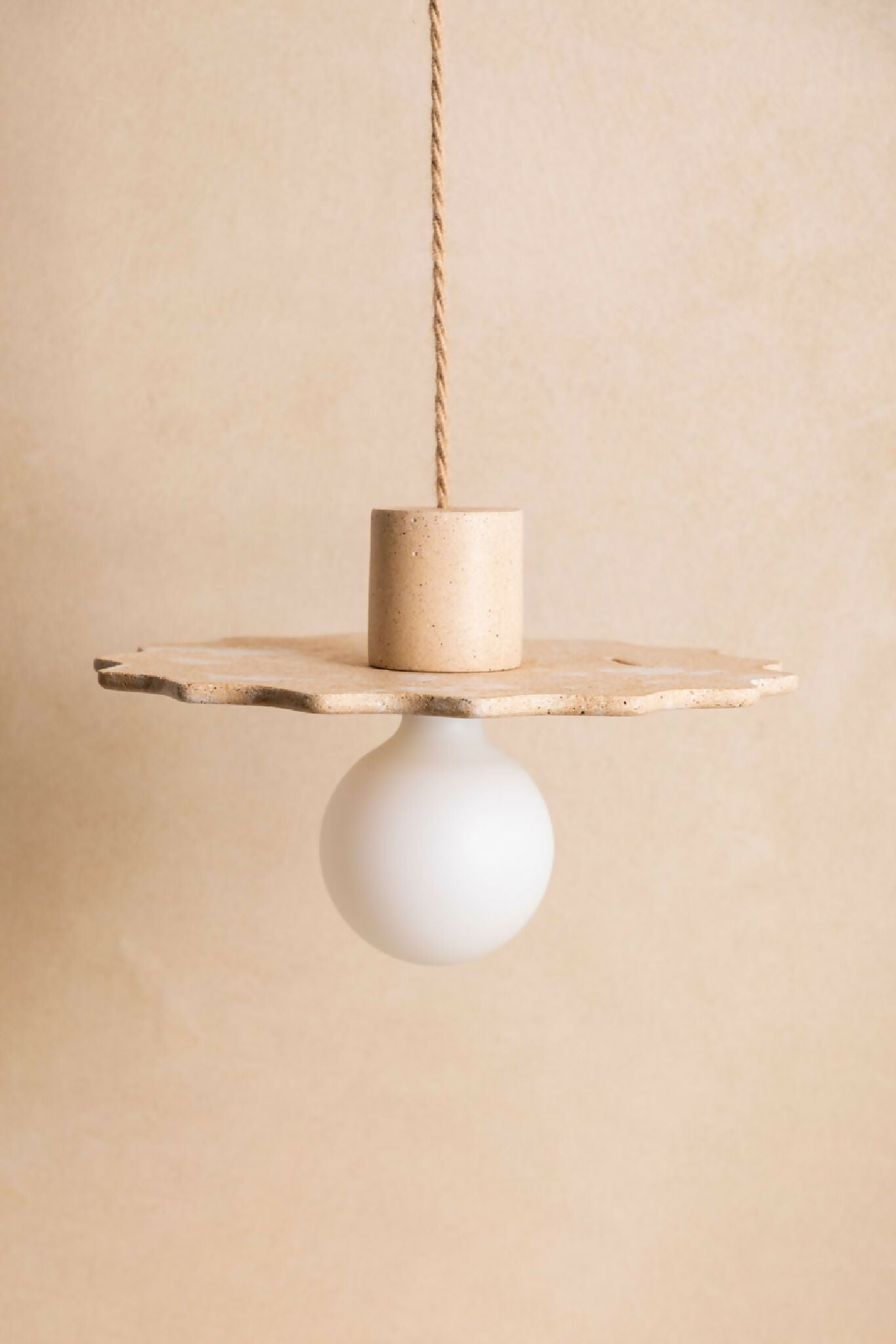 Suspension au diffuseur sphérique blanc, plateau irrégulier en métal finition sable.