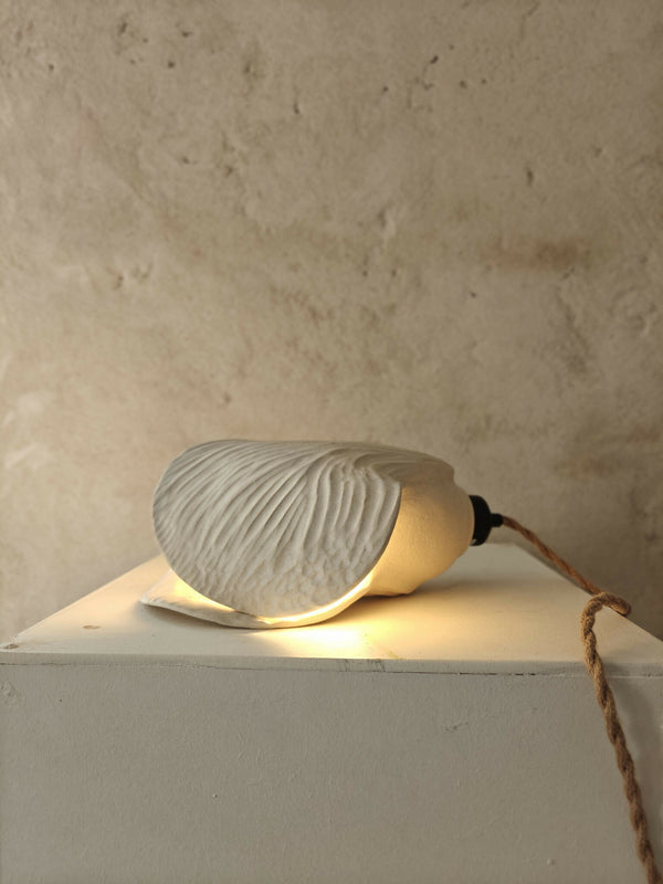 Lampe baladeuse cocoon à abat-jour côtelé beige, lumière chaude, câble brun.