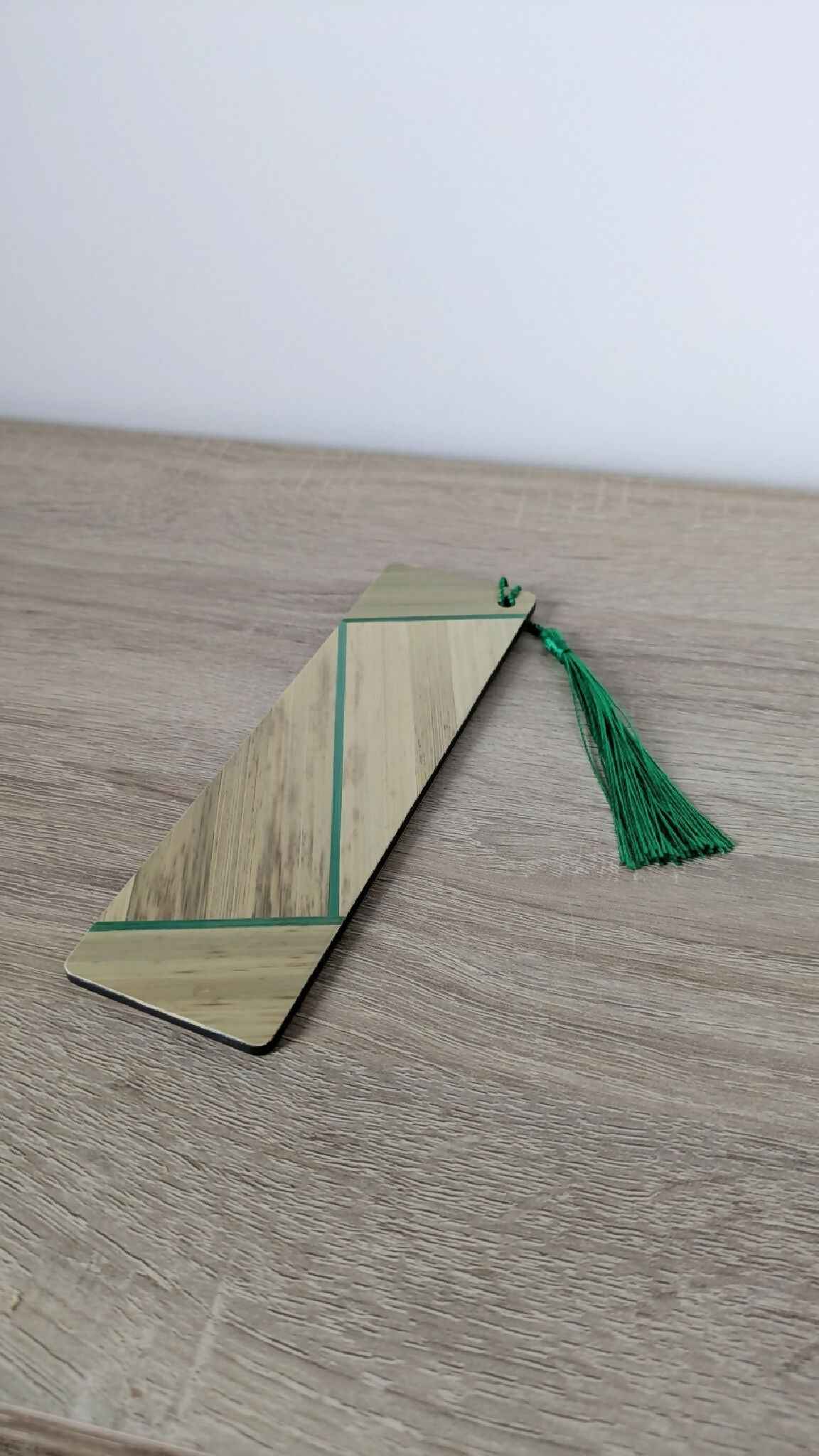 Marque-page en paille beige à bandes vertes, pompon vert sur ficelle