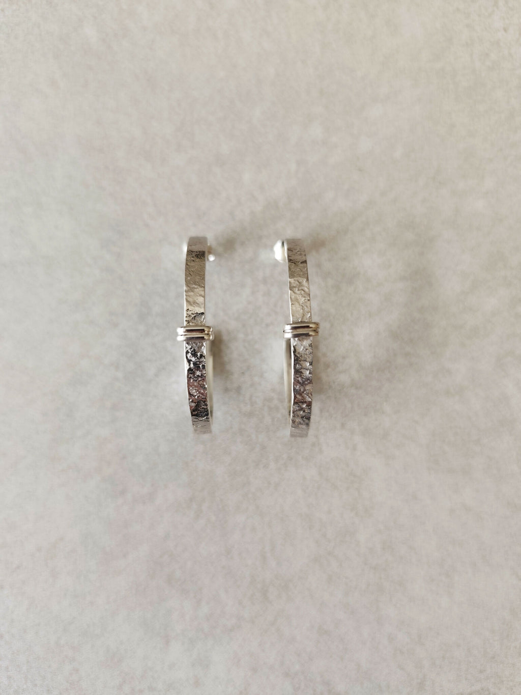 Boucles d’oreilles courbes argentées, fermeture à charnière, finition martelée