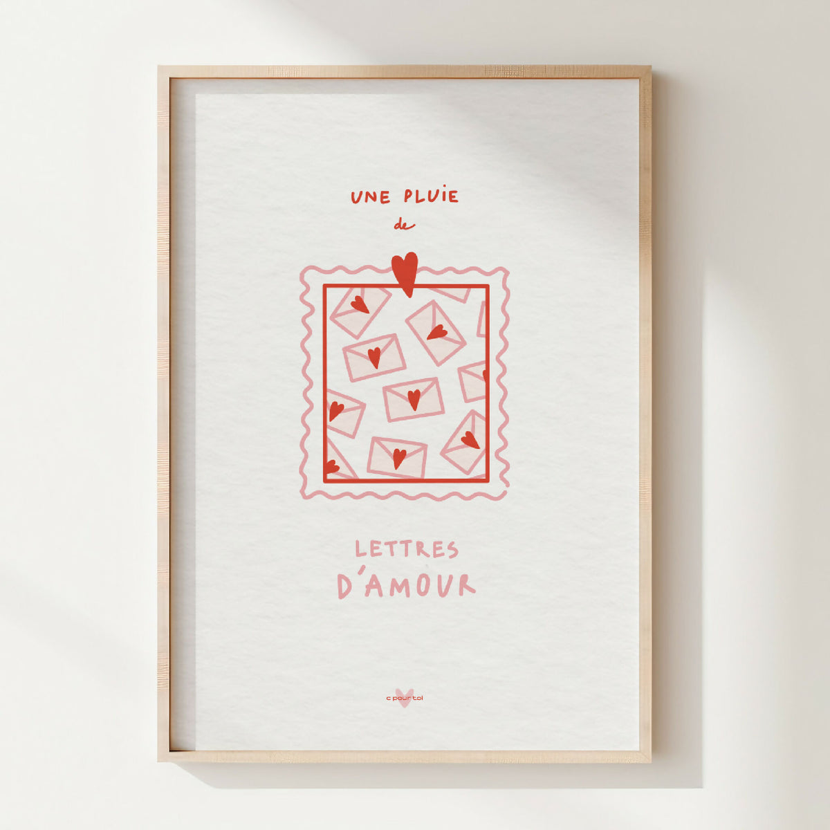 Affiche encadrée avec illustration rouge et texte « Une pluie de lettres d’amour ».