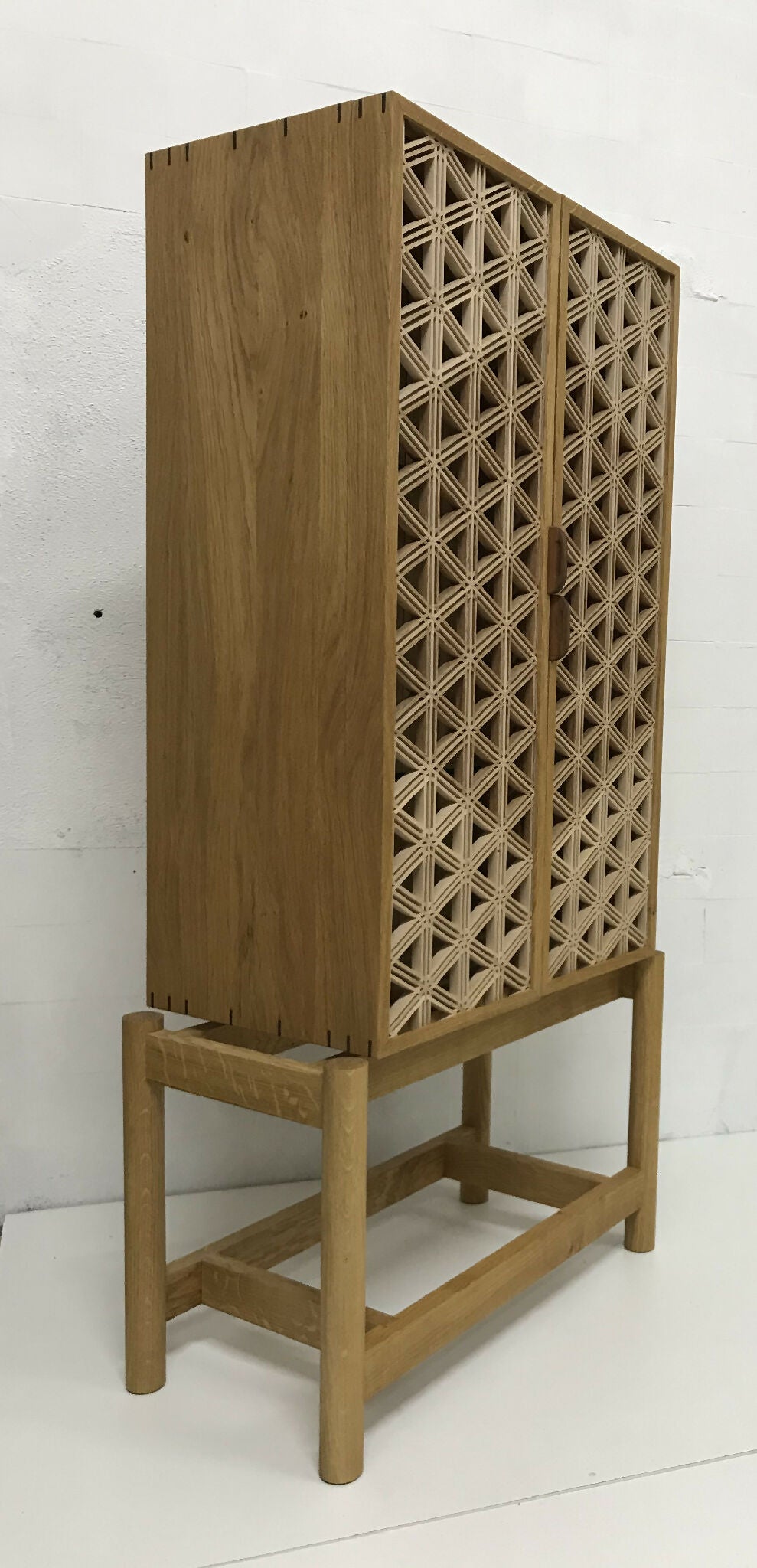 Vitrine en chêne ajourée, panneaux à croisillons sur le côté et structure sur pieds.