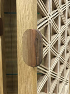 Détail du montant en chêne avec pastille ronde et panneau ajouré à croisillons.