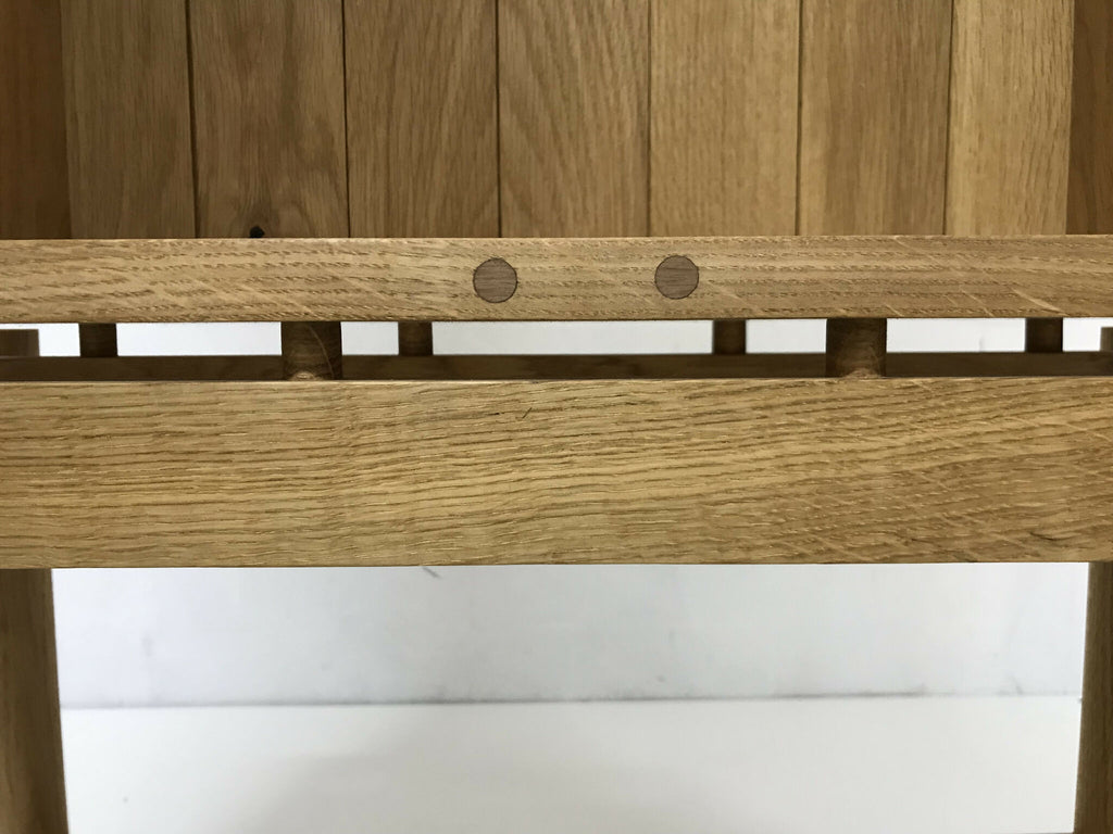 Étagère interne en chêne avec barre horizontale et fixations métalliques au bord.