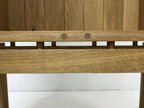 Étagère interne en chêne avec barre horizontale et fixations métalliques au bord.
