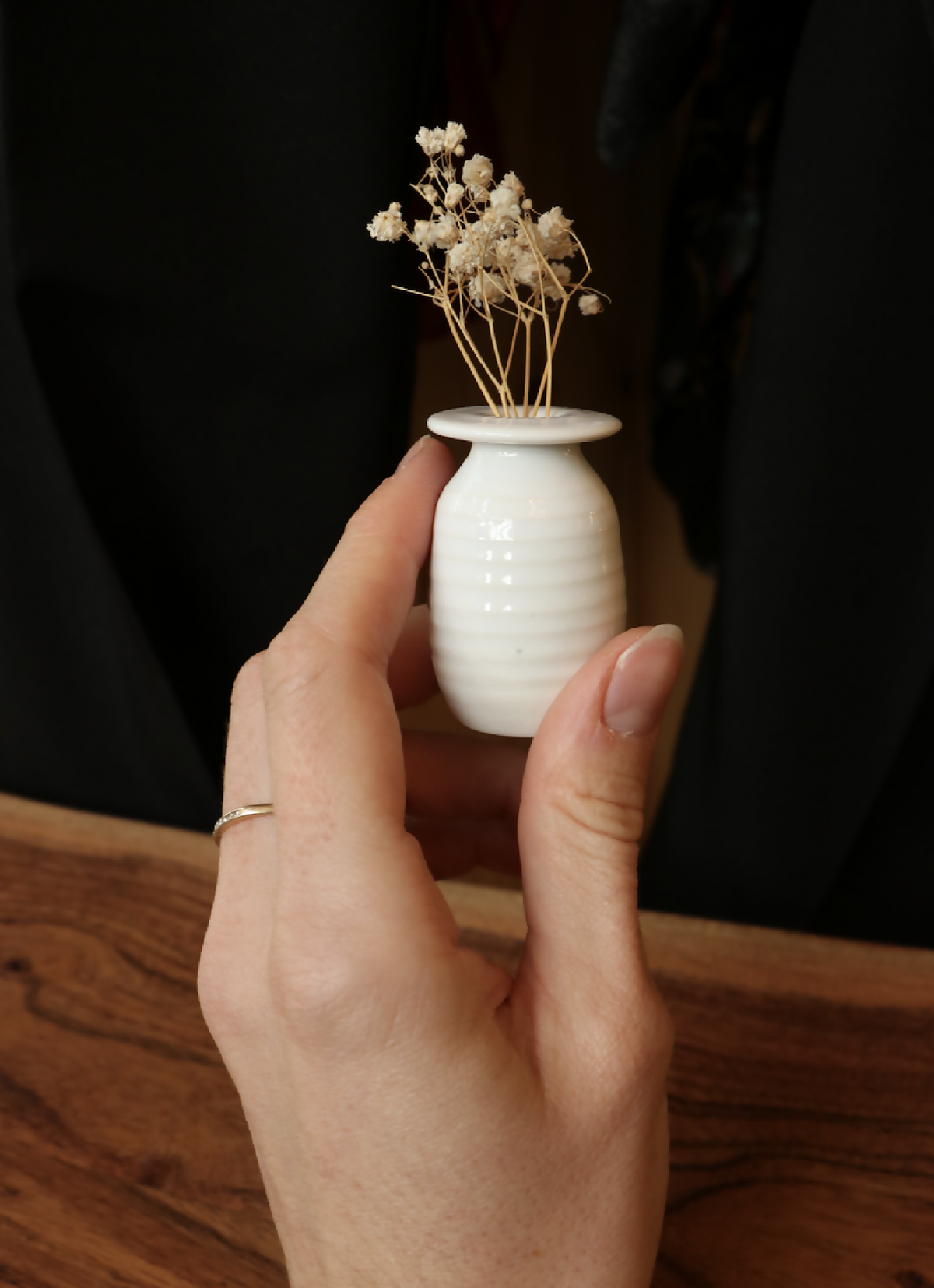 Mini-vase en porcelaine blanc tenu à la main, reliefs horizontaux, ouverture évasée