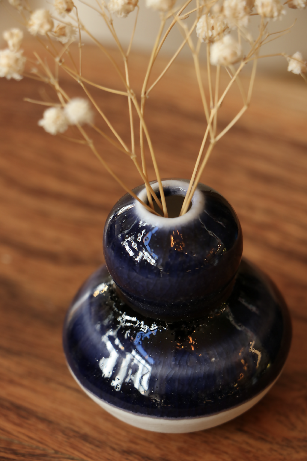 Mini-vase en porcelaine bleu nuit brillant, base blanche et ouverture avec tiges séchées