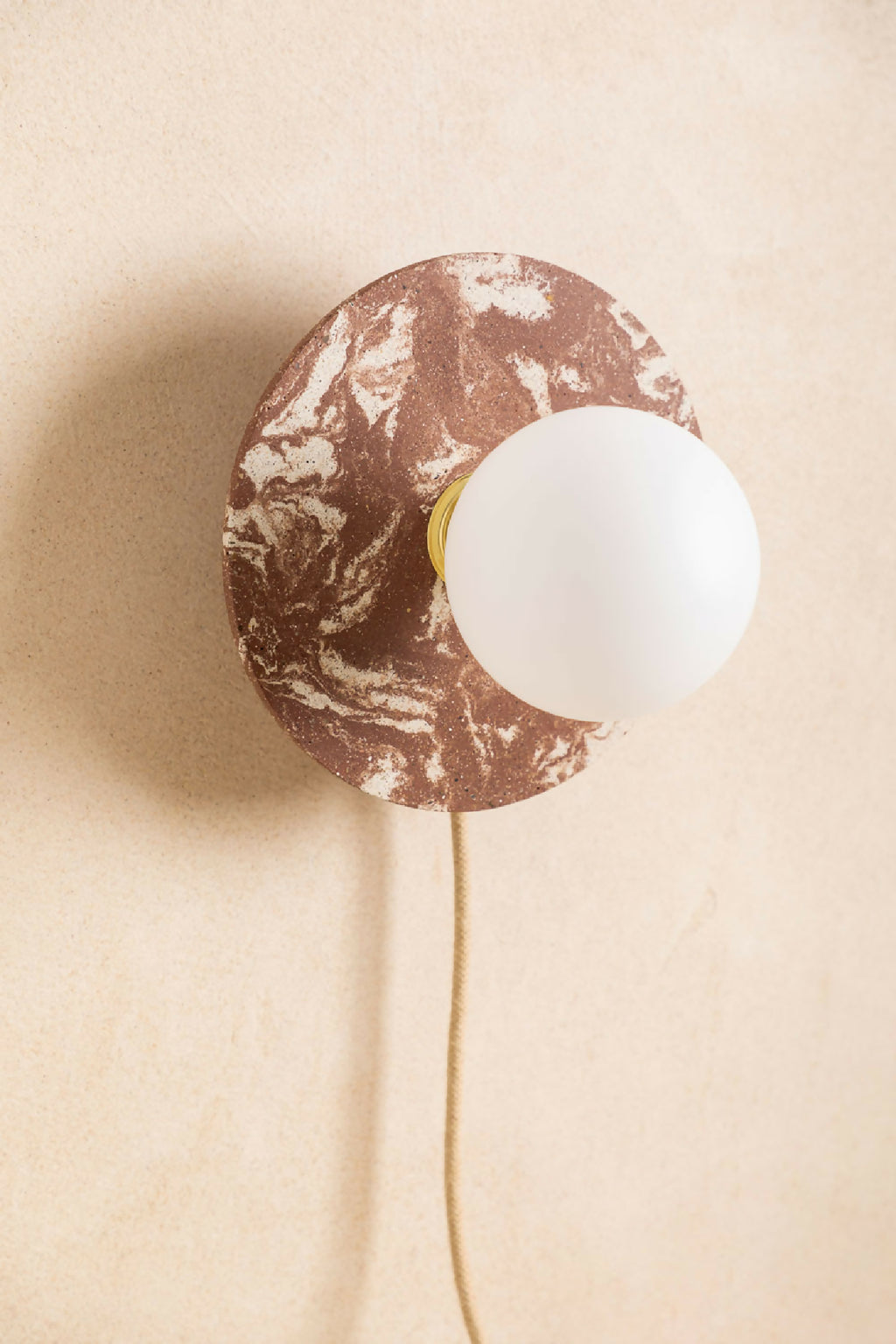 Applique murale ronde brun moucheté avec ampoule blanche, ouverture centrale, câble beige
