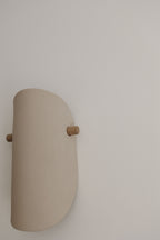 Applique murale en céramique beige, vue de côté, fixation en bois