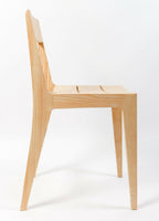 Chaise en bois clair, dossier sculpté et assise en lattes, pieds fins