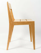 Chaise en bois clair, dossier haut incurvé et assise en bois lisse