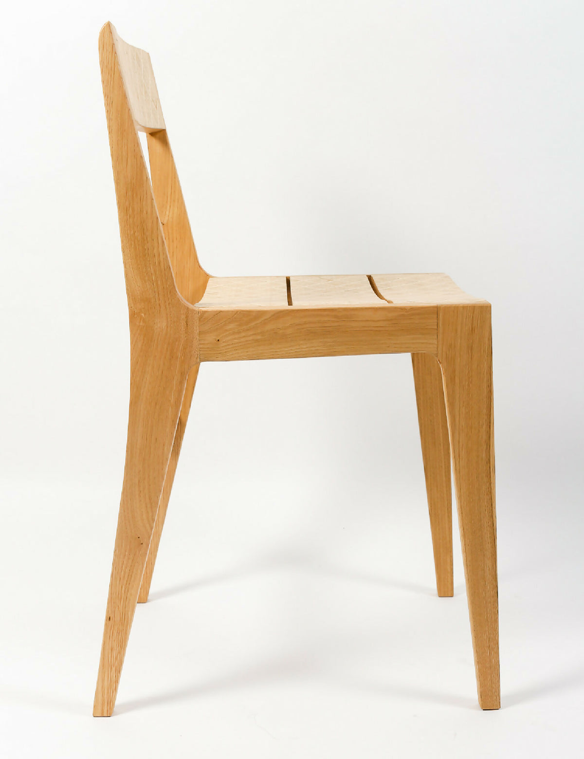 Chaise en bois clair, dossier haut incurvé et assise en bois lisse