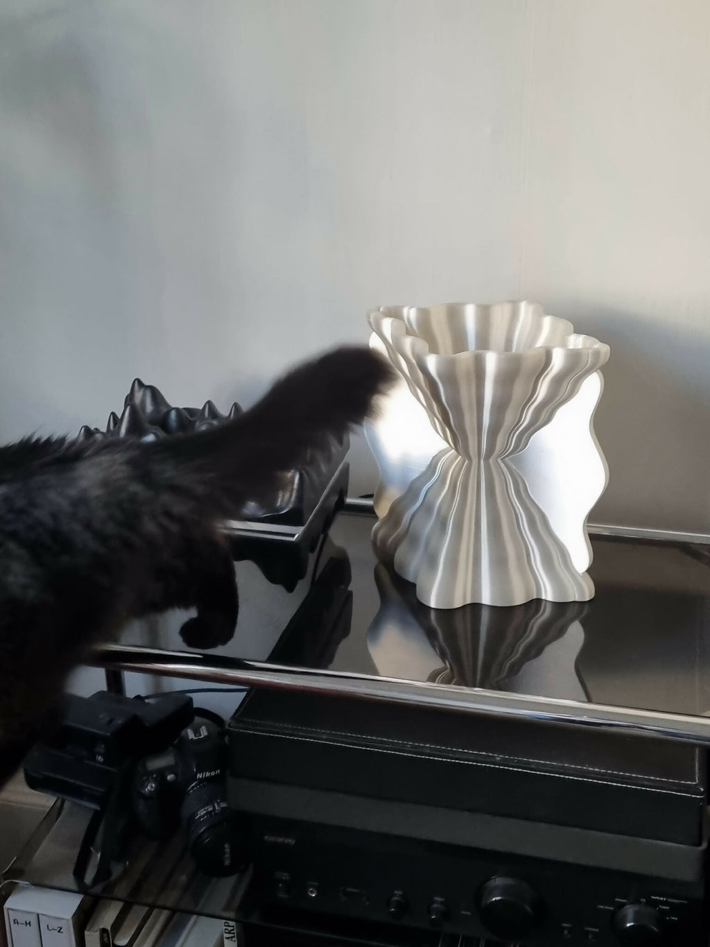 Lampe Galéa argentée, diffuseur ondulé, posée sur un meuble.