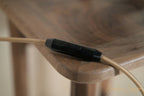 Interrupteur noir sur câble pour lampe, détail près du bois