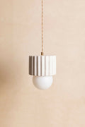 Suspension ILONA à abat-jour cylindrique blanc texturé et ampoule ronde blanche.