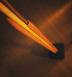 Lampe sur pied : tiges en bois et abat-jour en voile orange, allumée