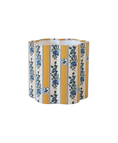 Abat-jour forme fleur en tissu à rayures jaunes et motifs floraux bleu, bord ondulé.