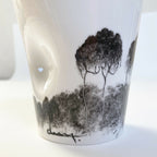 Mug en porcelaine blanc, vue rapprochée du paysage noir et gris sur la face