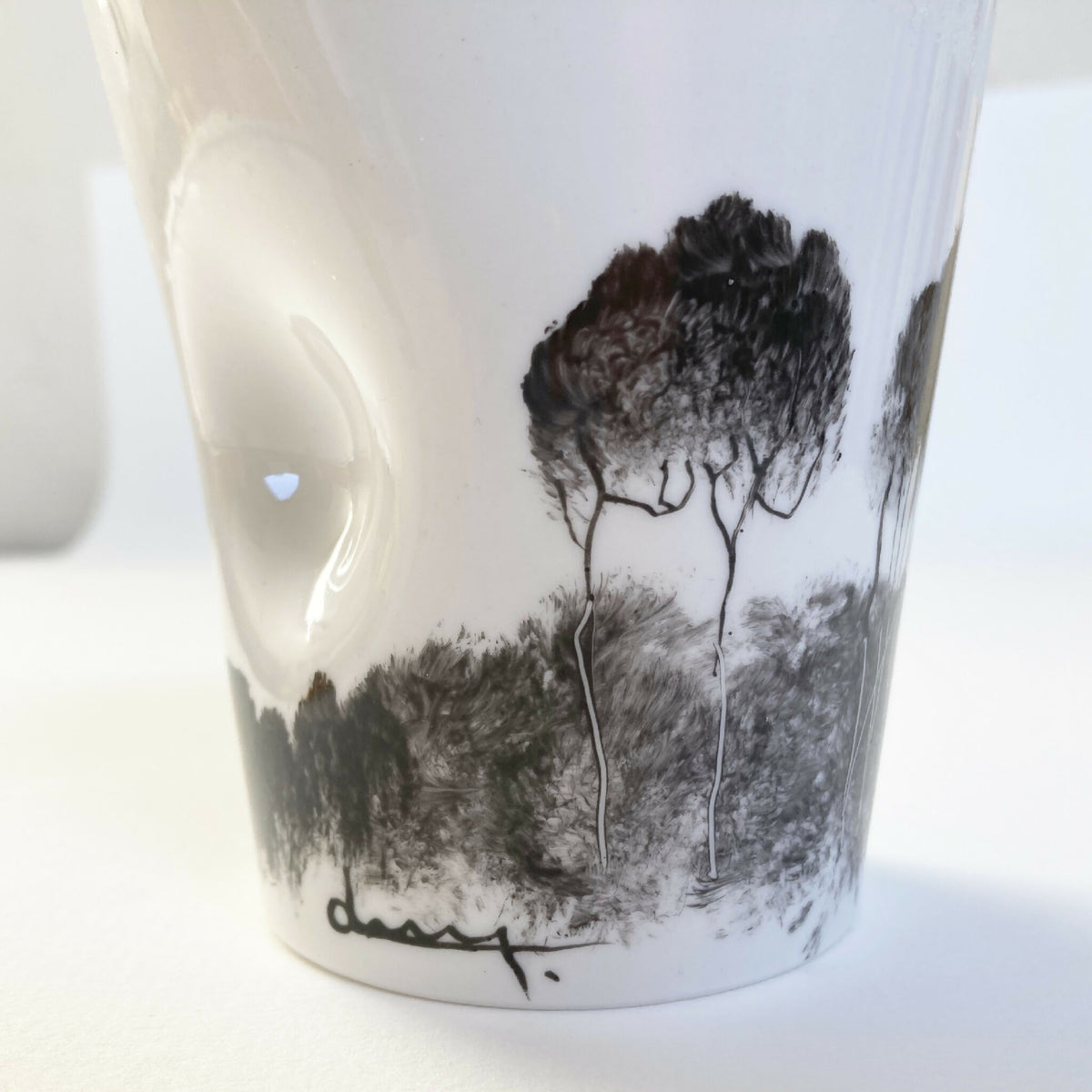 Mug en porcelaine blanc, vue rapprochée du paysage noir et gris sur la face