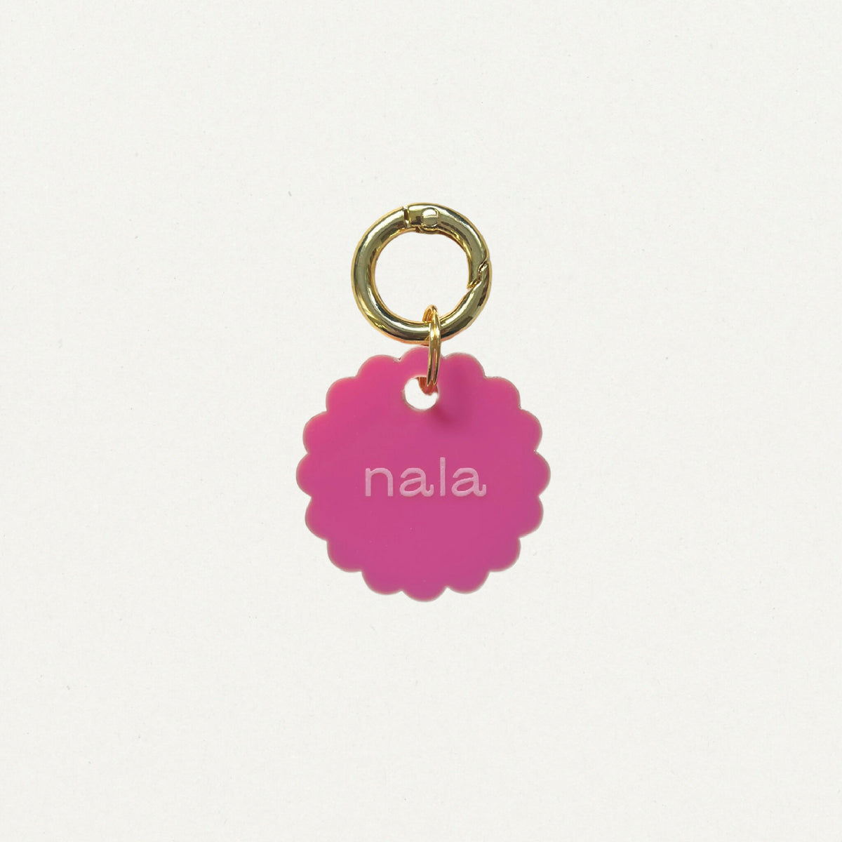 Médaille Bloom en émail rose, anneau doré, texte « nala » au centre.