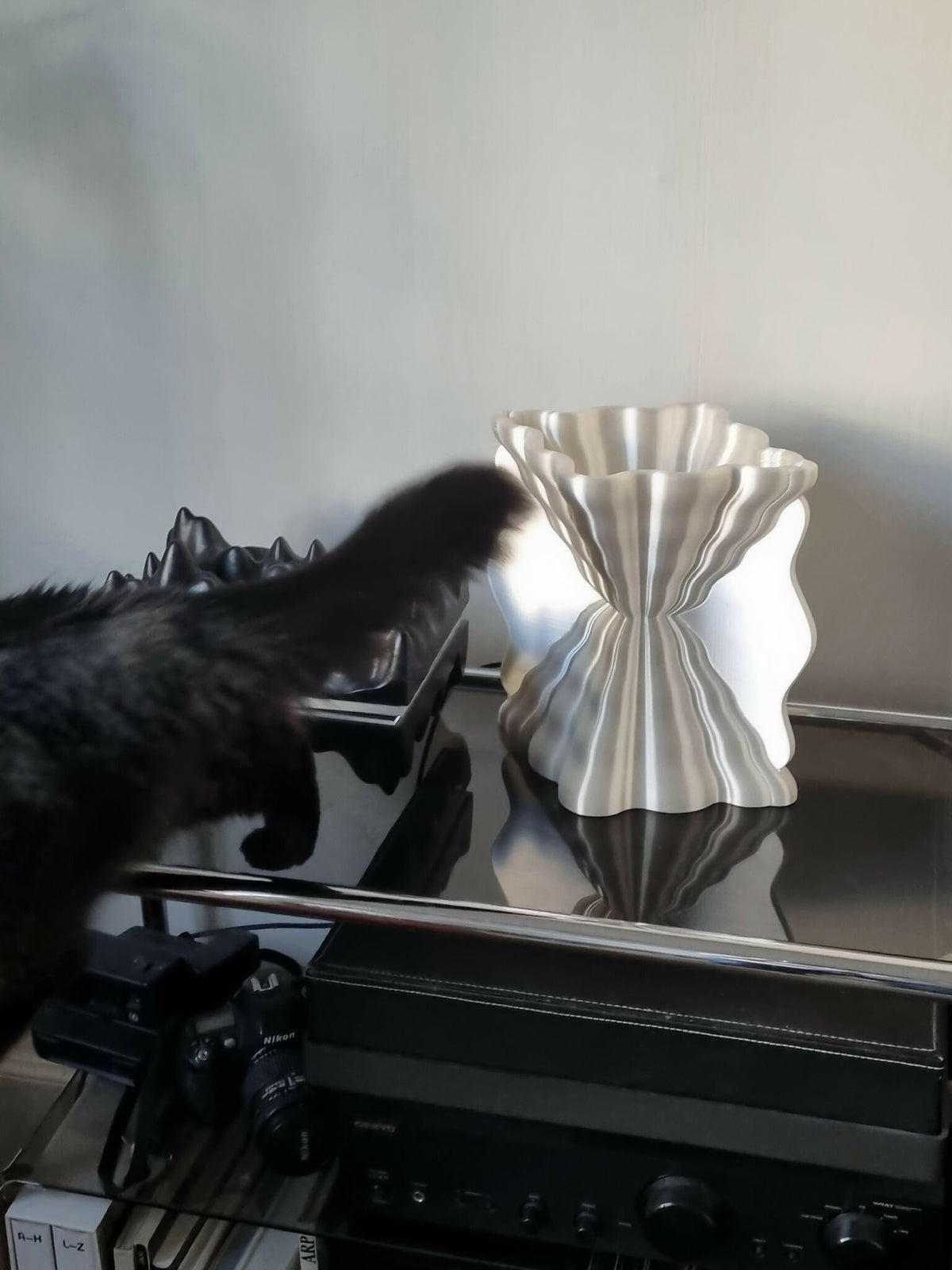 Lampe Galéa argentée, diffuseur ondulé, posée sur un meuble.