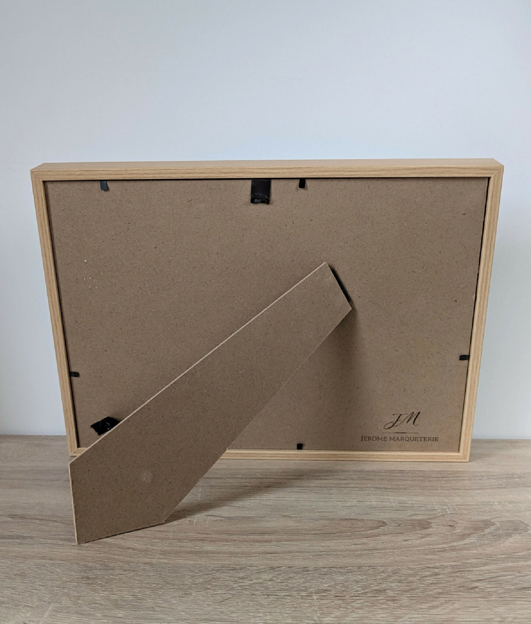 Dos de tableau encadré en bois, système d’accrochage et marquage.