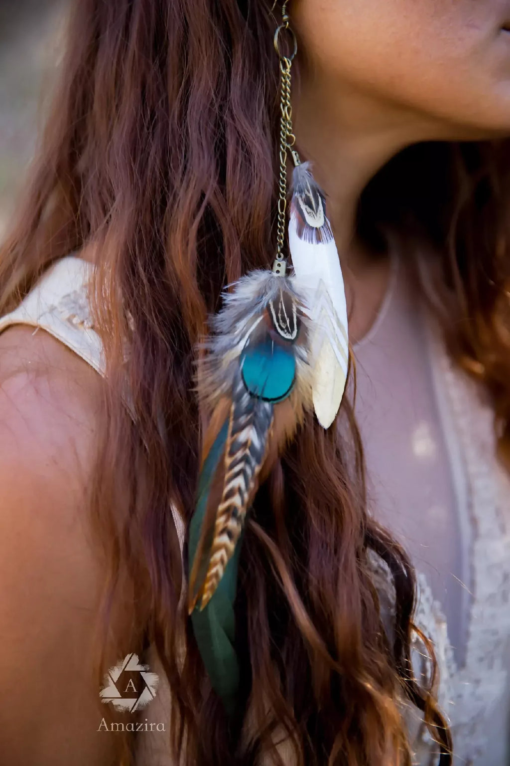 Détail des boucles d’oreilles plume turquoise, chaînette dorée pendante