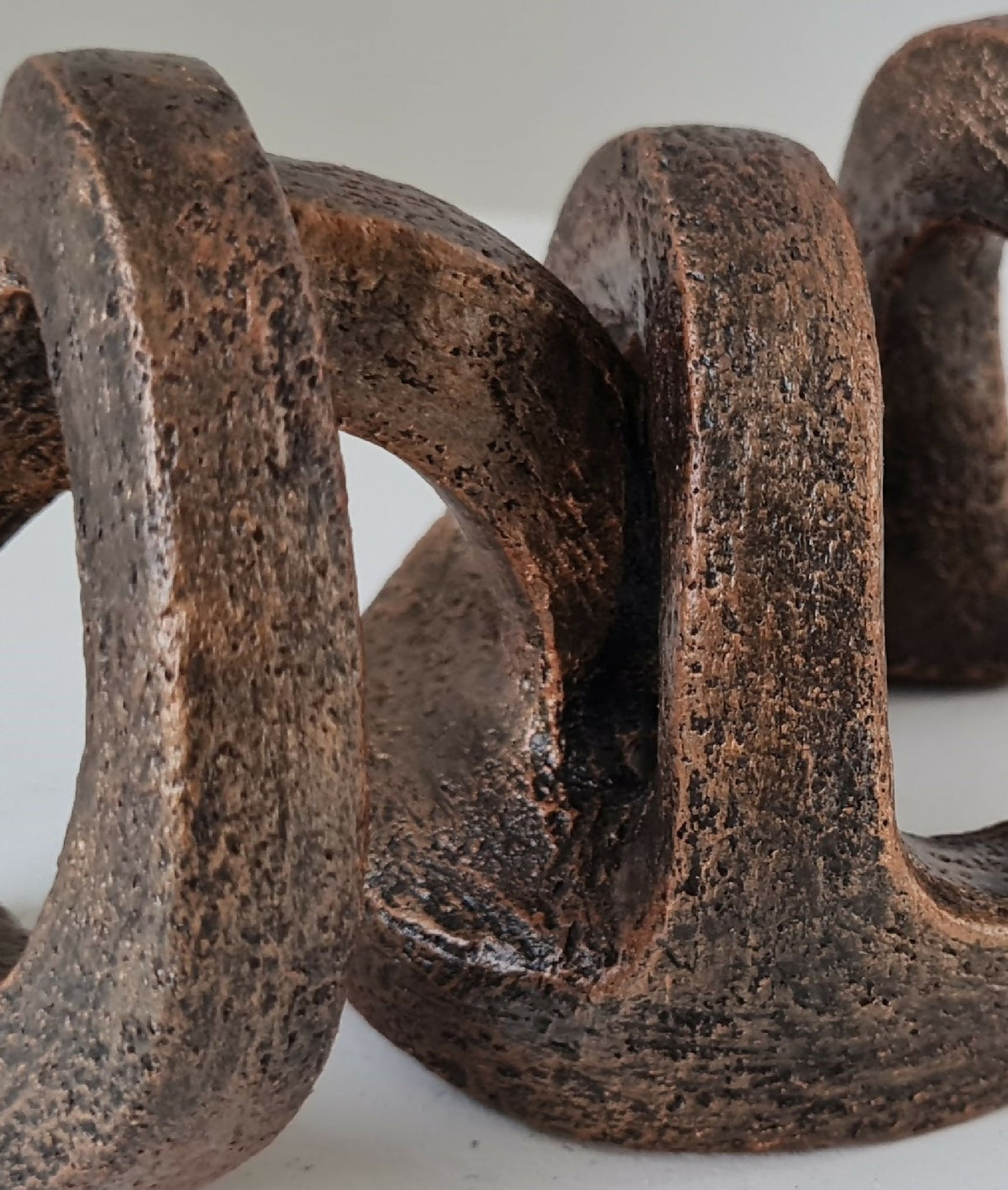 Sculpture abstraite brun foncé, détail texturé avec anneaux ajourés