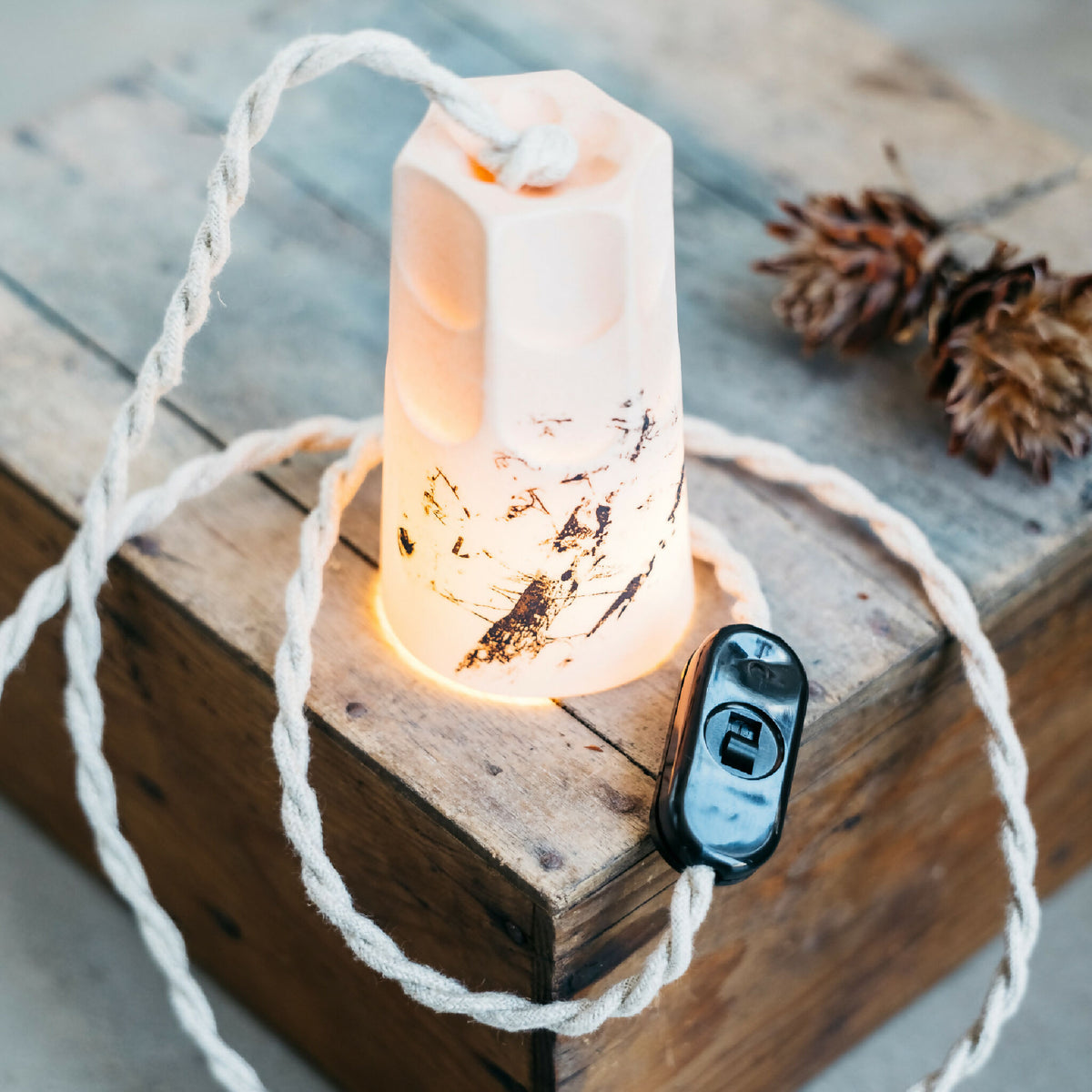 Lampe mini liseuse en porcelaine blanche, éclairée sur socle bois, décor doré sur la gaine
