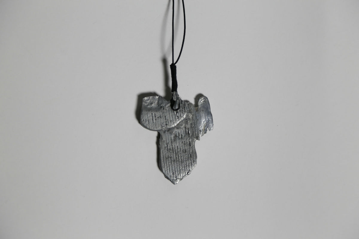 Pendentif argenté-gris en forme de feuille, détail de texture, sur cordon.