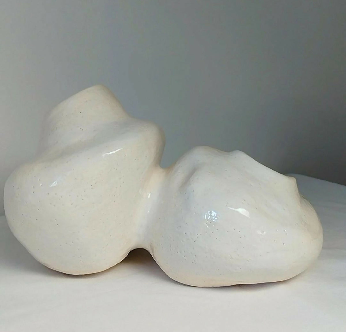 Sculpture décorative en céramique beige en forme de chat, vue arrière arrondie
