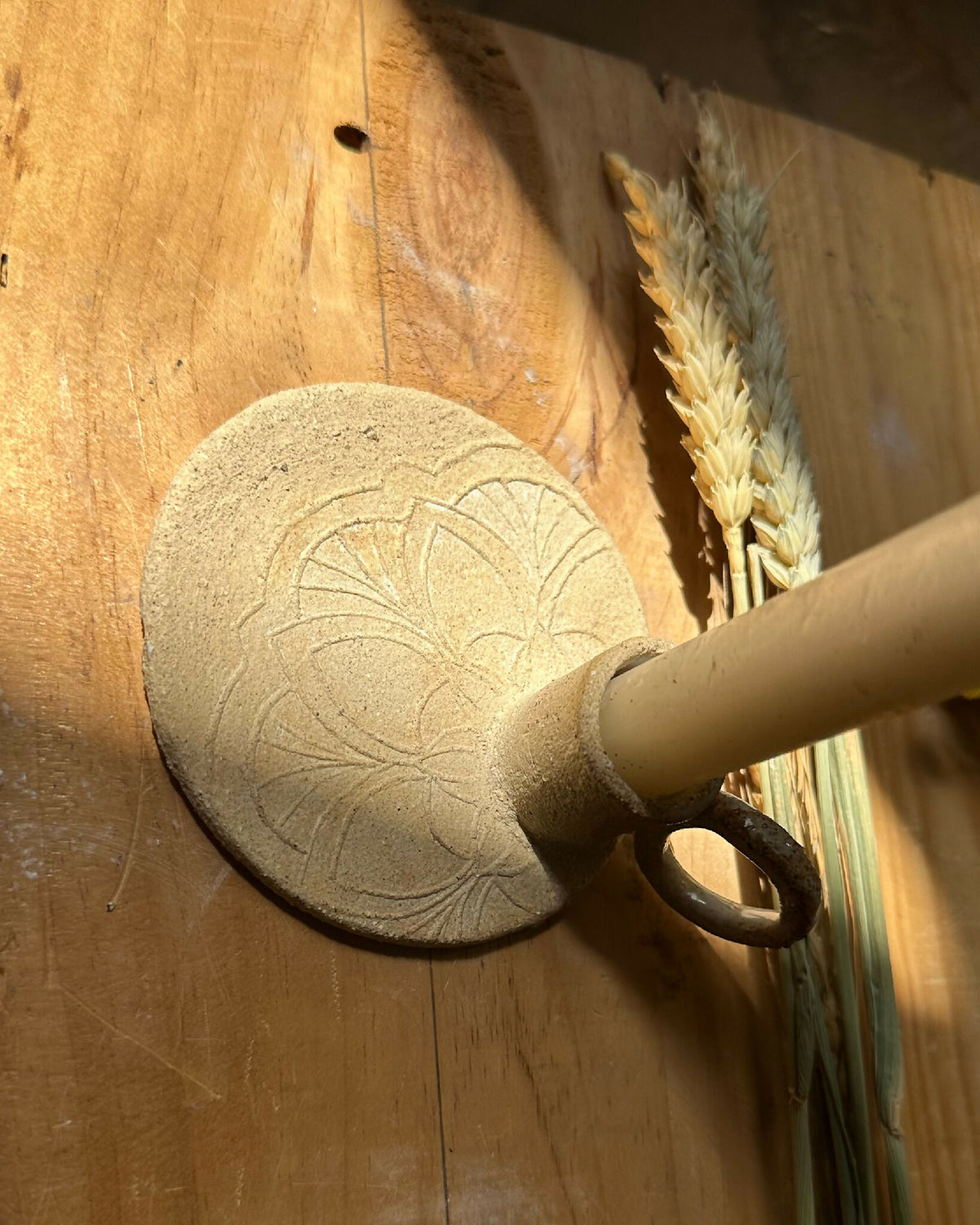 Bougeoir Circé rond en bois clair gravé, bougie insérée dans le support.