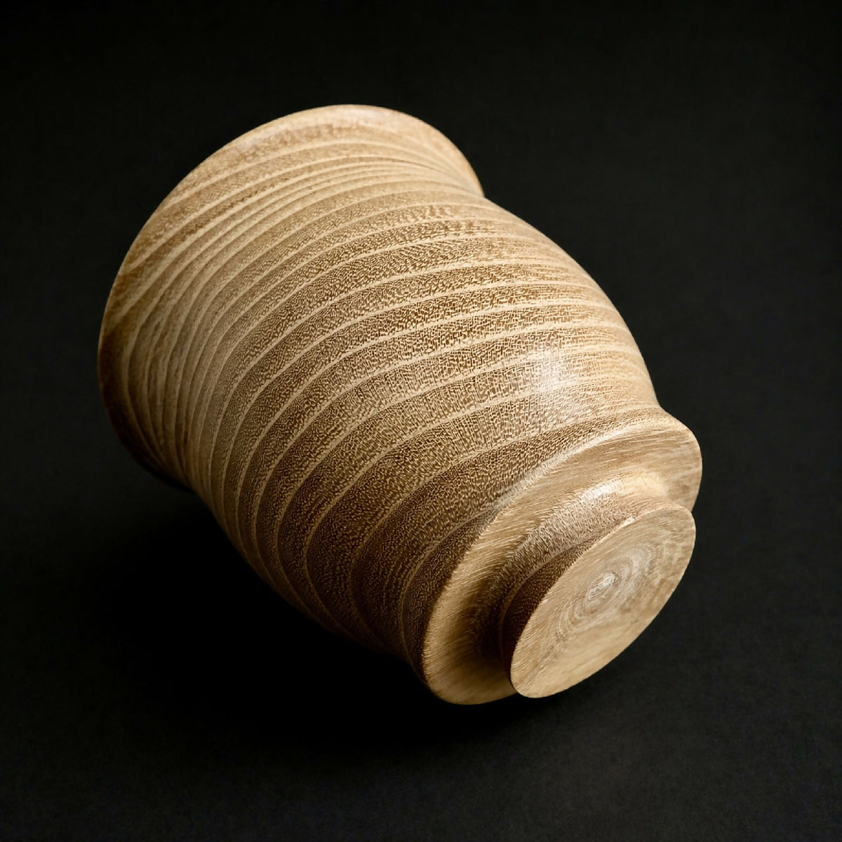 Gobelet en céramique beige à texture mouchetée, vue de dessous arrondie.