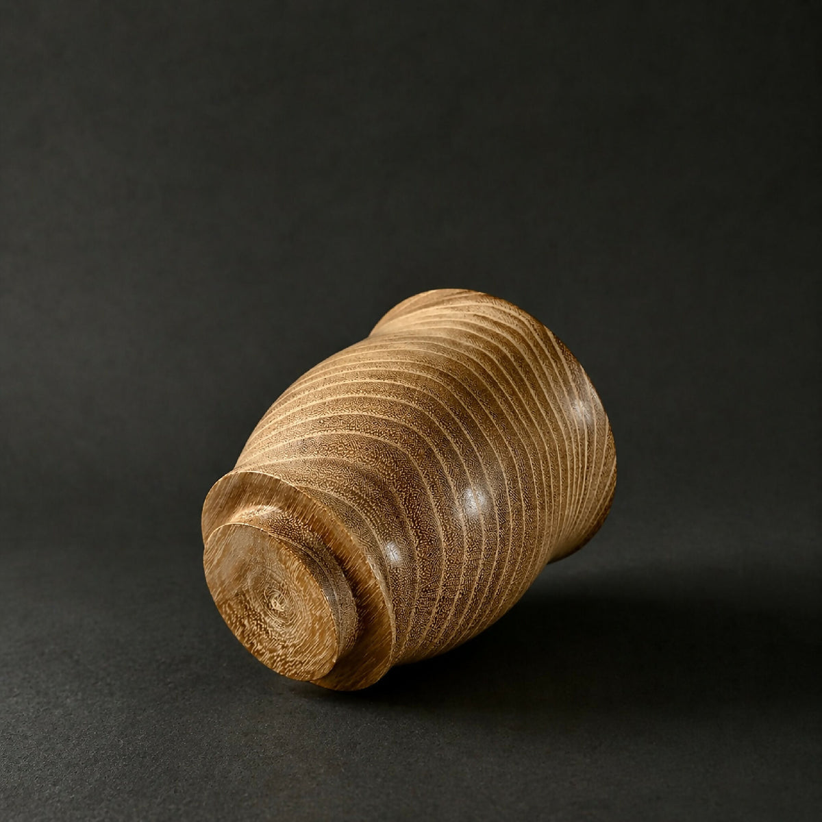 Gobelet en céramique beige, lignes ondulées sur la surface cylindrique.