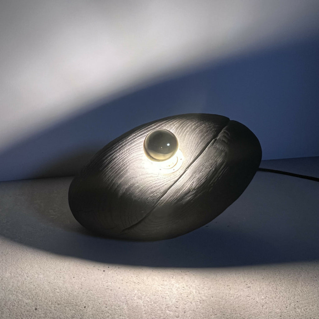 Galet lumineux noir avec LED intégrée, lueur chaude.