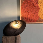 Galet lumineux sur socle en bois, lumière LED dorée.