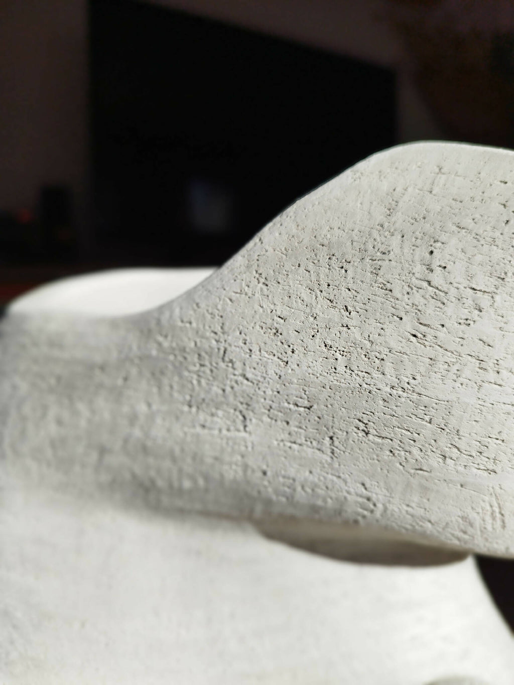 Masque décoratif blanc, gros plan sur la texture granuleuse mate