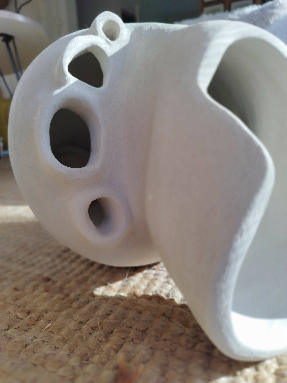 Objet décoratif blanc en forme de masque, ouvertures en cœurs et ovales