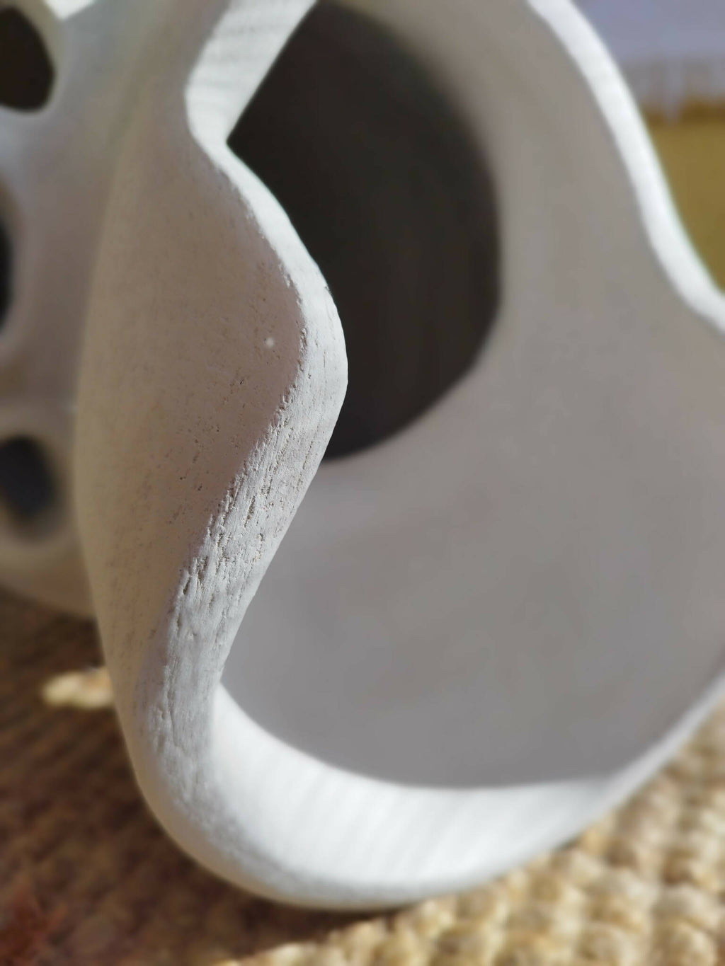 Gros plan sur masque décoratif blanc ajouré, texture mate et ouverture sombre